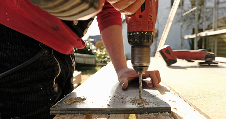 Ein Mitarbeiter der Dachdeckerei Roof-Tec aus Taarstedt bearbeitet Holz